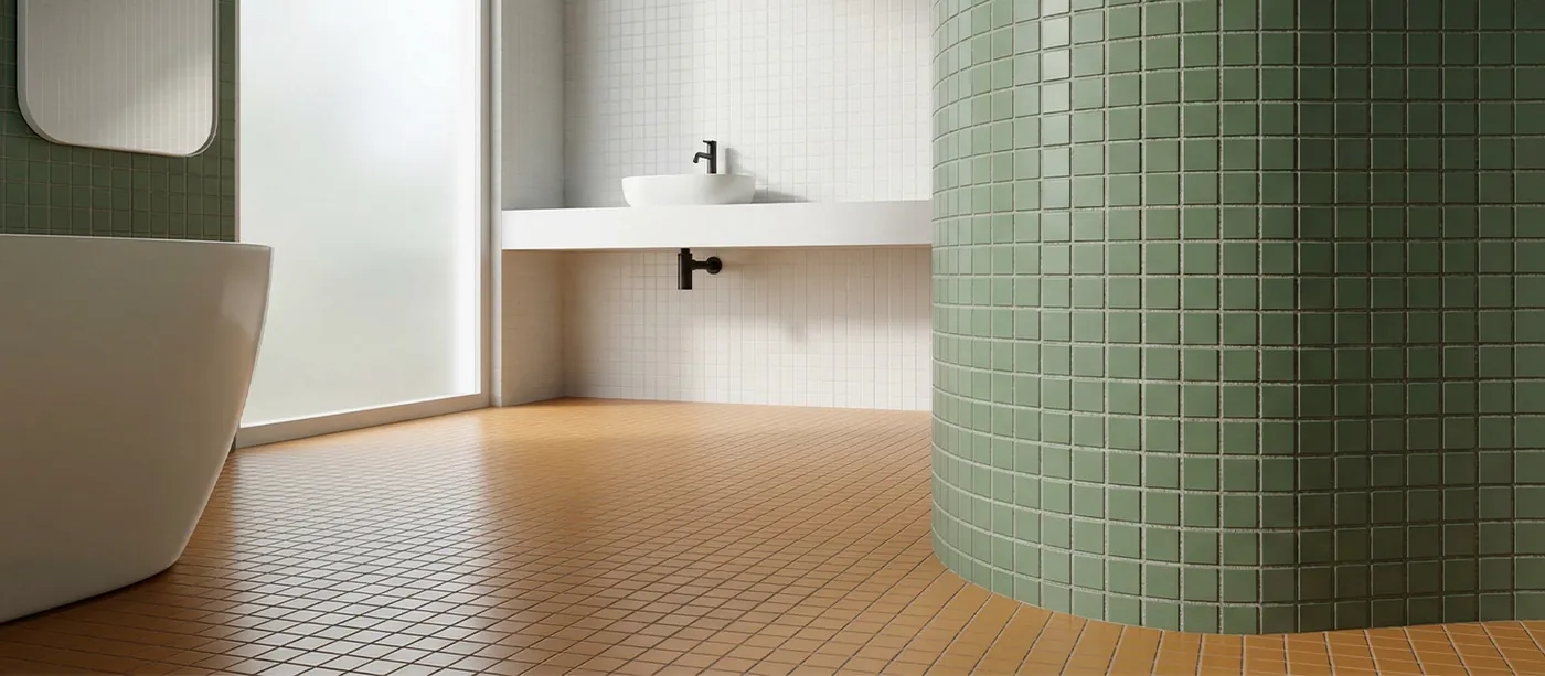 Baño con pared curva revestida de mosaico cerámico verde, bañera exenta y lavabo suspendido